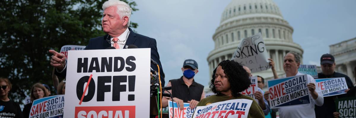 Rep. John Larson stands with sign reading, "Hands off Social Security."