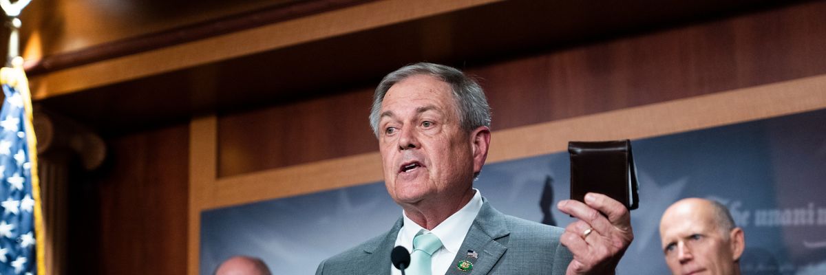 Rep. Ralph Norman holds his wallet while speaking at a news conference