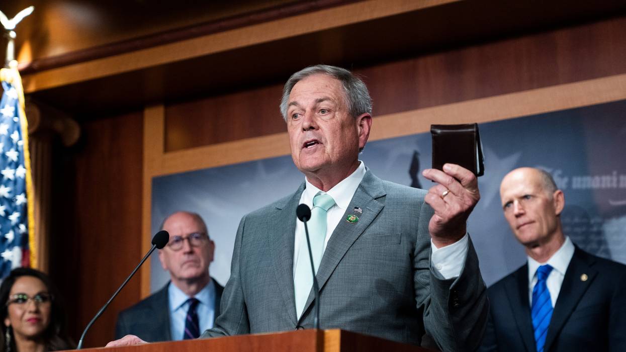 Rep. Ralph Norman holds his wallet while speaking at a news conference
