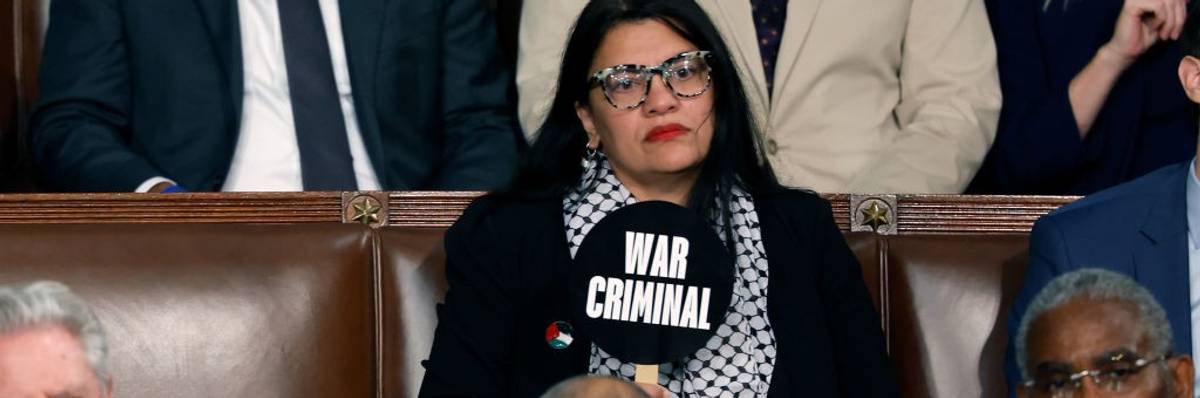 Rep. Rashida Tlaib holds a sign reading "war criminal" during Israeli Prime Minister Benjamin Netanyahu's speech.