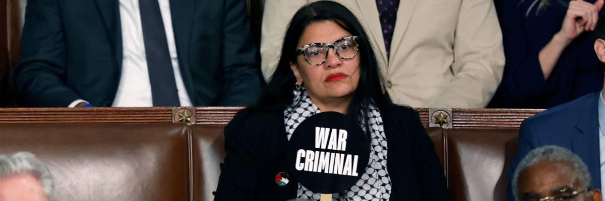 Rep. Rashida Tlaib holds a sign reading "war criminal" during Israeli Prime Minister Benjamin Netanyahu's speech.