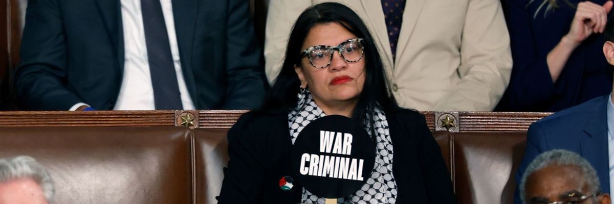 Rep. Rashida Tlaib holds a sign reading "war criminal" during Israeli Prime Minister Benjamin Netanyahu's speech.