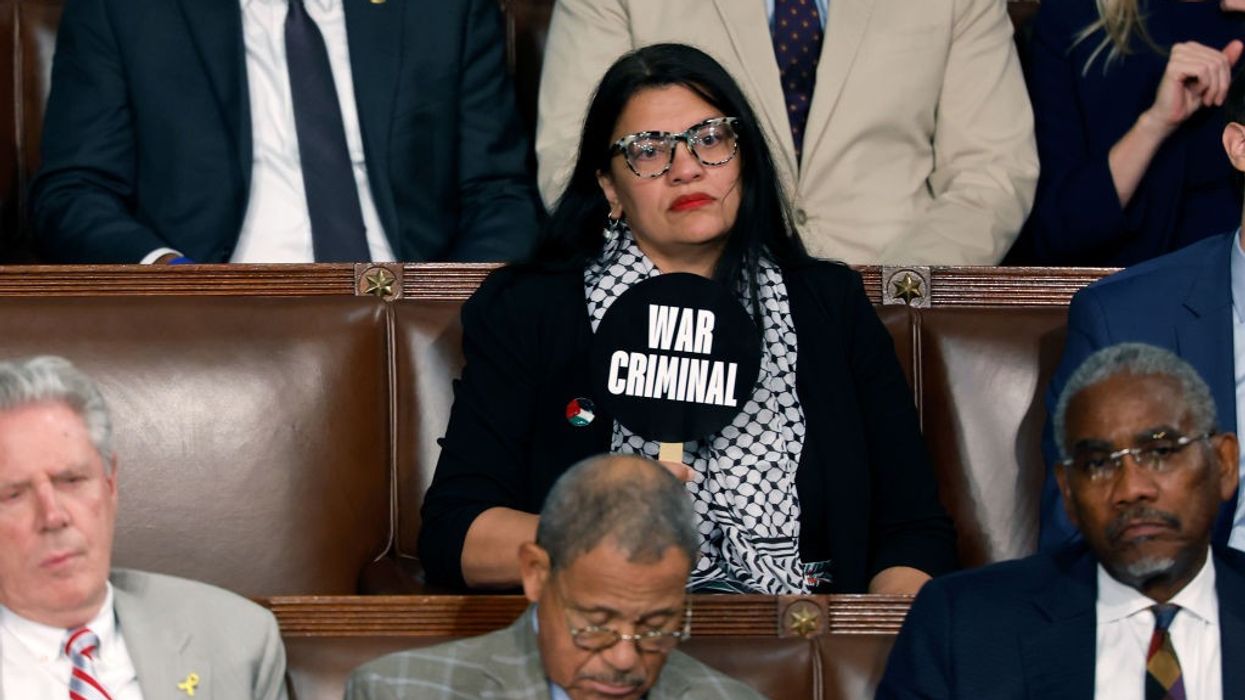 Rep. Rashida Tlaib holds a sign reading "war criminal" during Israeli Prime Minister Benjamin Netanyahu's speech.