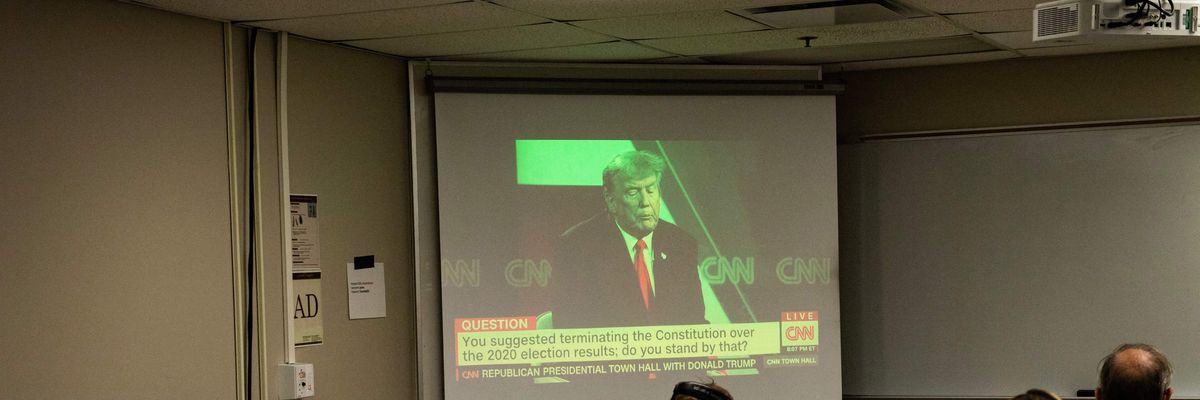 Reporters watch a CNN town hall with former President Donald Trump