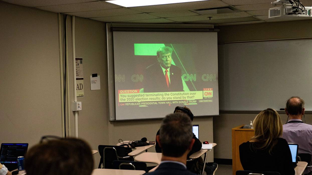 Reporters watch a CNN town hall with former President Donald Trump