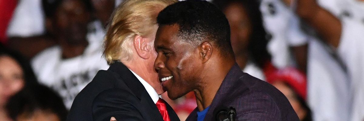 Republican Senate candidate Herschel Walker and former President Donald Trump embrace at a rally in Perry, Georgia on September 25, 2021