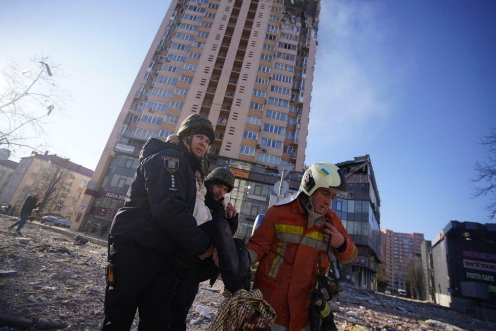 Rescue workers evacuate a wounded person after a missile struck a residential building during Russia's military assault on Kyiv, Ukraine on February 26, 2022.