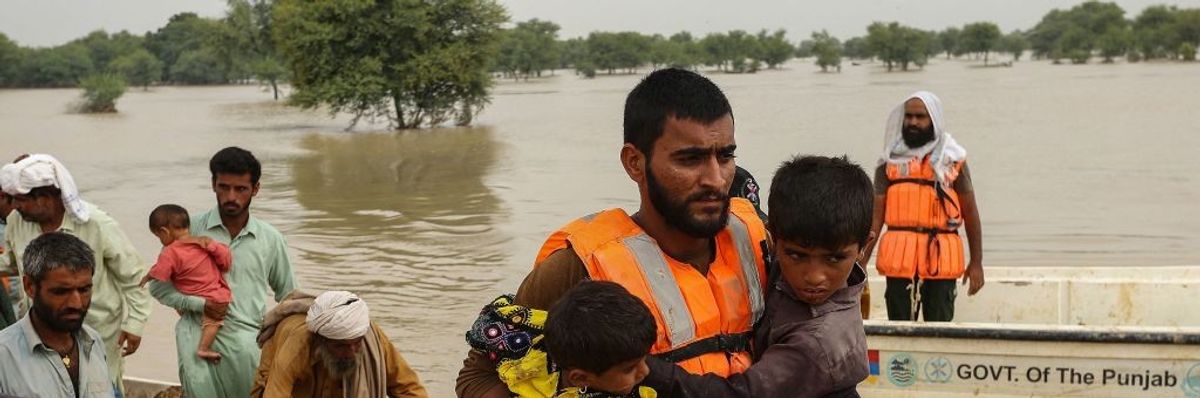 Rescue workers help evacuating flood-affected people from their flood hit homes following heavy monsoon rains in Rajanpur district of Punjab province on August 27, 2022.