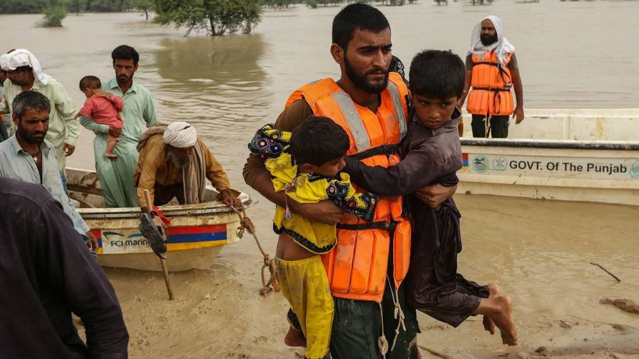 Rescue workers help evacuating flood-affected people from their flood hit homes following heavy monsoon rains in Rajanpur district of Punjab province on August 27, 2022.