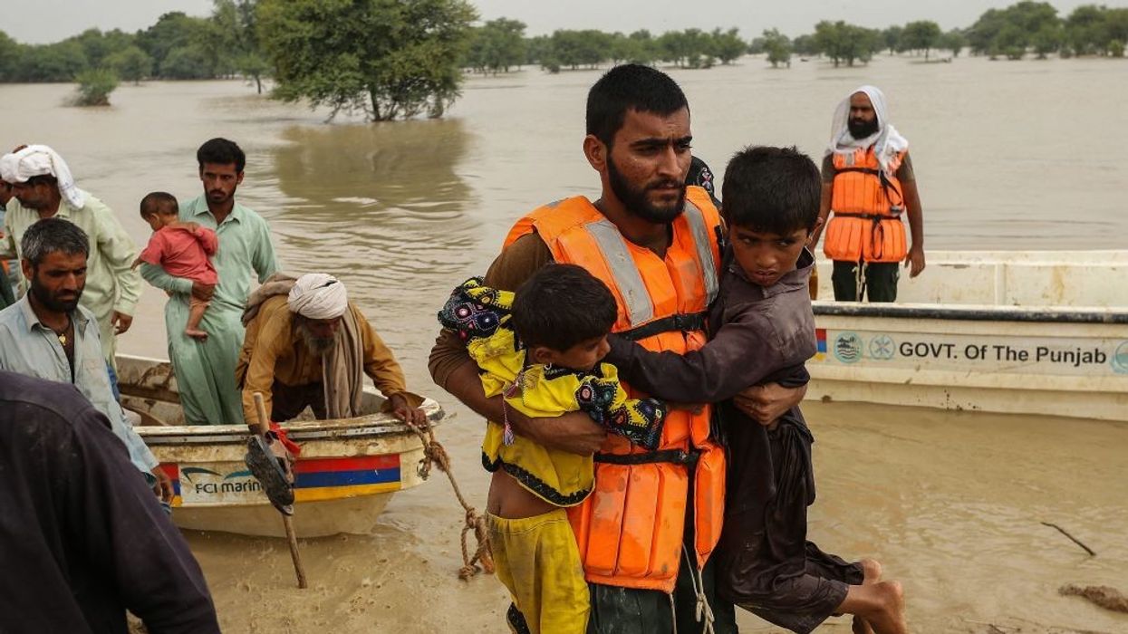 Rescue workers help evacuating flood-affected people from their flood hit homes following heavy monsoon rains in Rajanpur district of Punjab province on August 27, 2022.