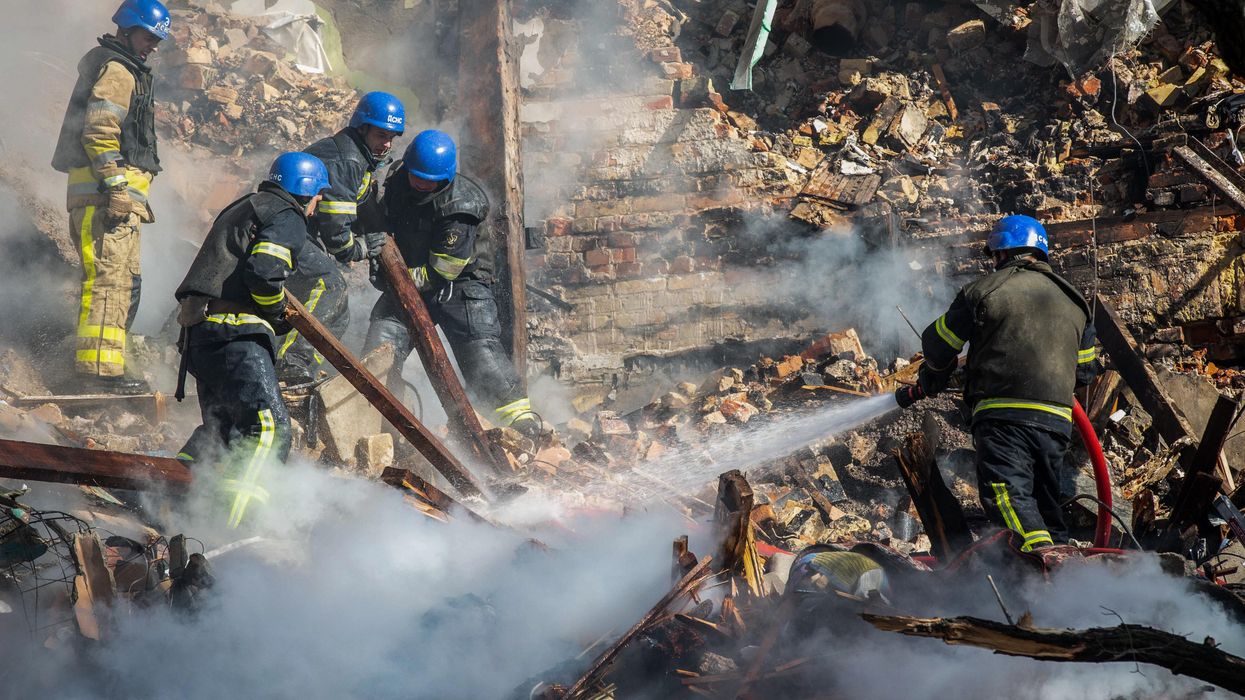 Rescue workers pour water on rubble following Russian attack on Kyiv