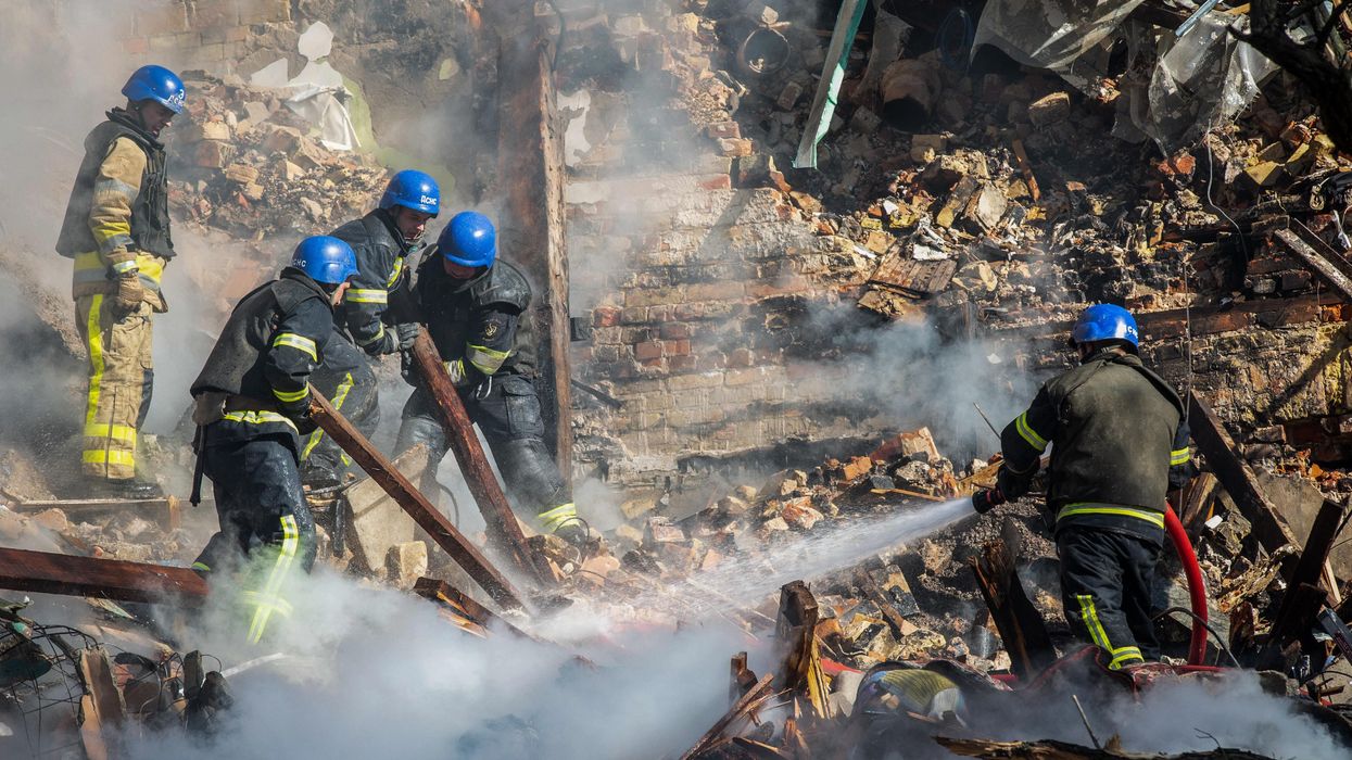 Rescue workers pour water on rubble following Russian attack on Kyiv