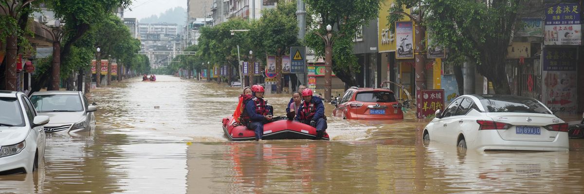 Rescuers help evacuate residents from a flooded street in Rongjiang