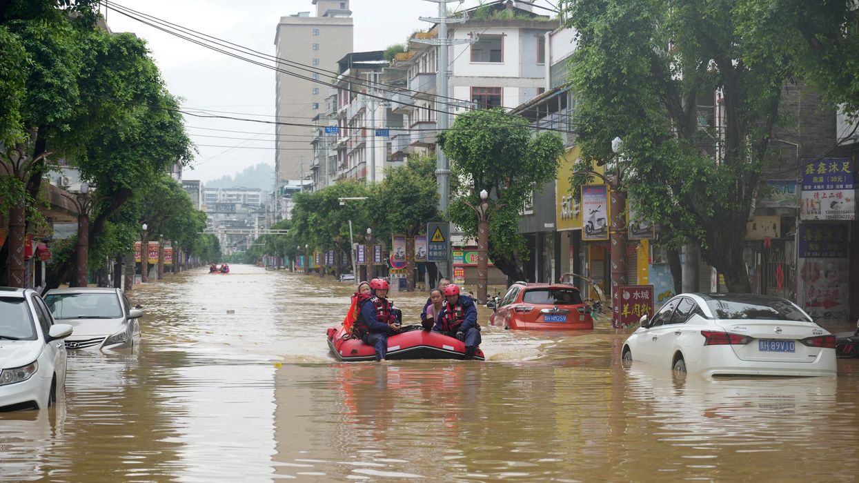 Rescuers help evacuate residents from a flooded street in Rongjiang