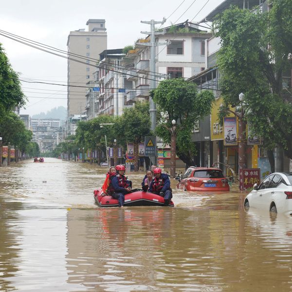 ​Rescuers help evacuate residents from a flooded street in Rongjiang