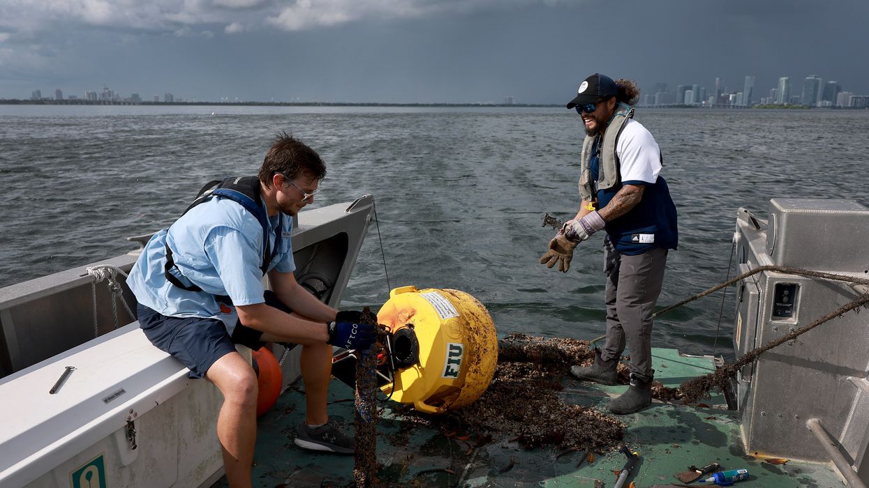 Researchers conduct routine maintenance on a research buoy