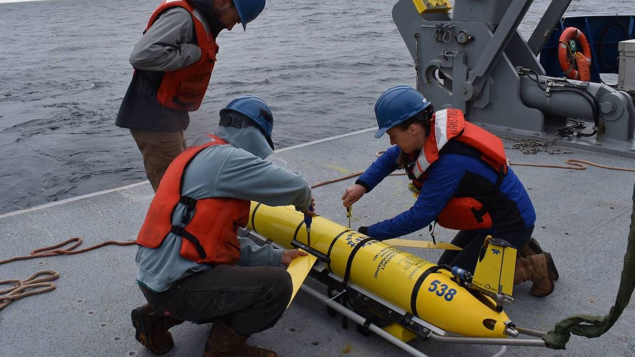 Researchers prepare to deploy a glider instrument into the ocean. 