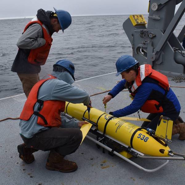 Researchers prepare to deploy a glider instrument into the ocean. 