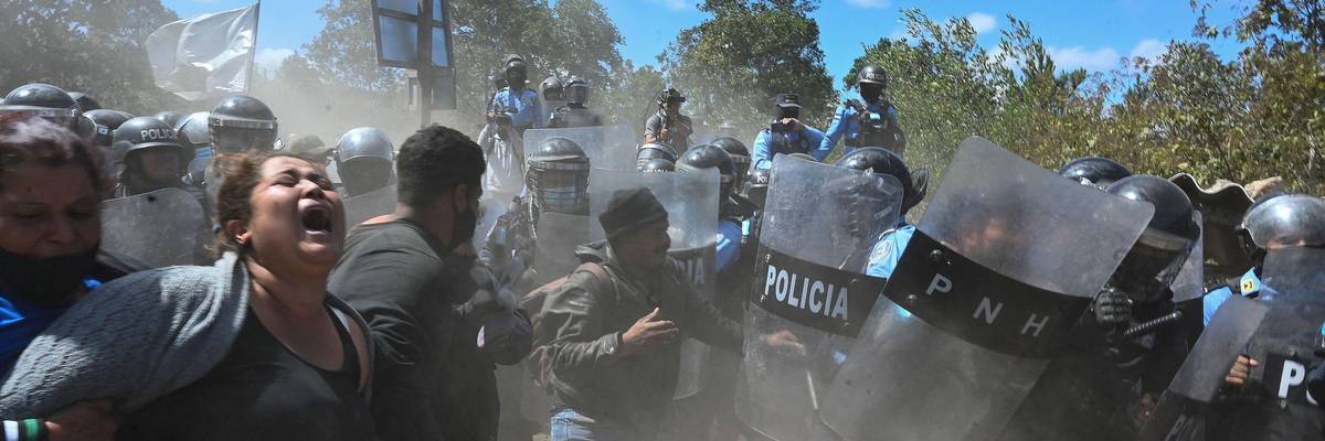 Residents face riot police during an attempted eviction at Tierras del Padre, a Lenca Indigenous community between the municipalities of Ojojona and San Buenaventura, Francisco Morazan department, Honduras, on February 9, 2022.