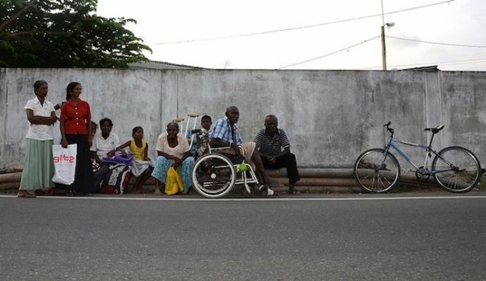 Residents from the coastal areas of Ratmalana, a Colombo suburb, wait by the roadside after being evacuated from their homes following a tsunami warning on April 11, 2012. Poor families, living in coastal areas, are most vulnerable to natural disasters. (Photo: Indika Sriyan/IPS)
