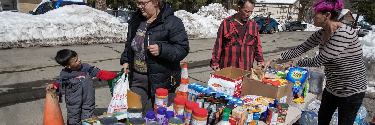 Residents gather food and supplies from a volunteer food pantry