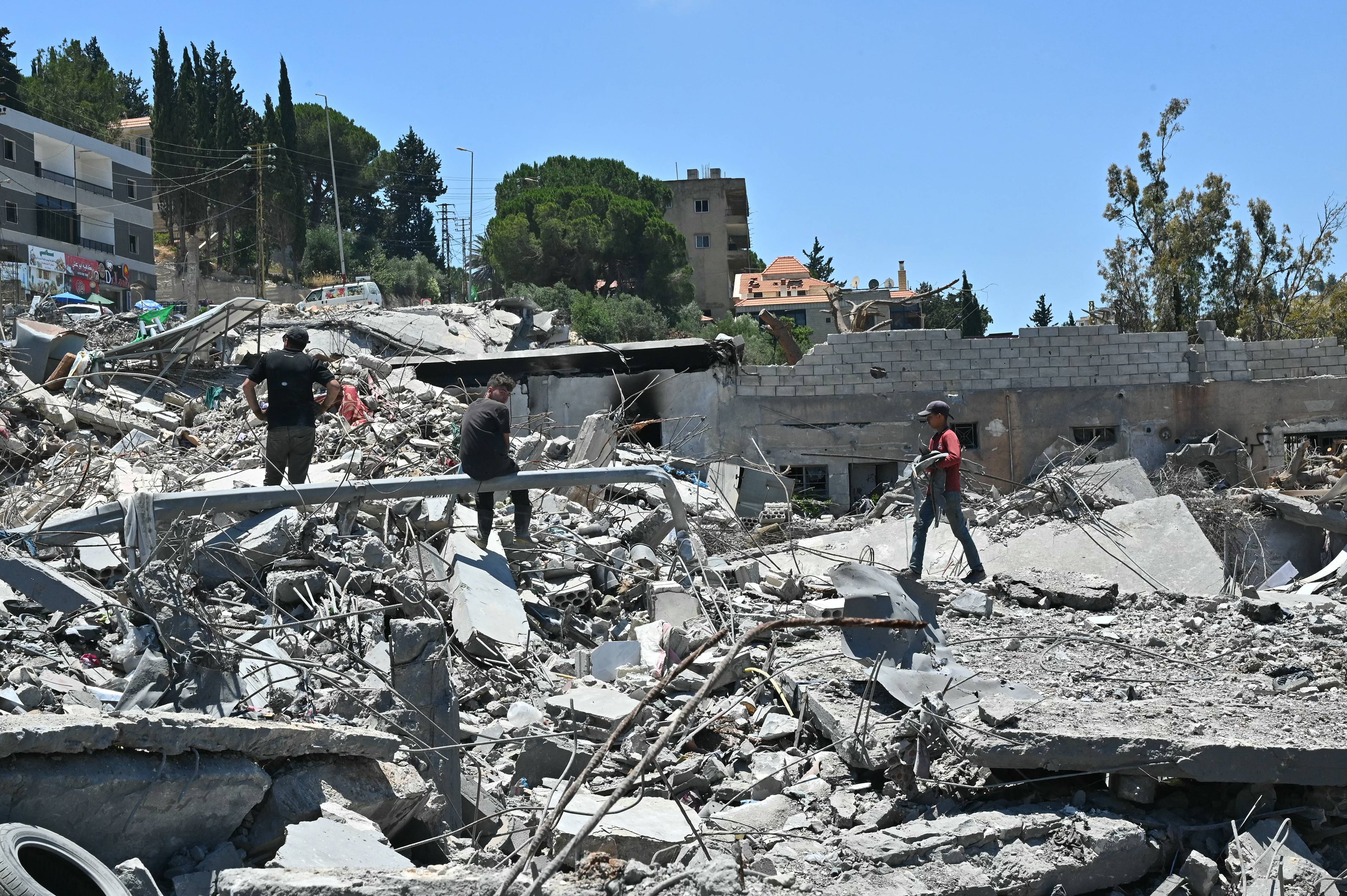 Residents look through the rubble of their homes in Lebanon.