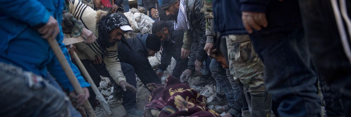 Residents retrieve a body from the rubble of a collapsed building in the province of Latakia, Syria on February 8, 2023.