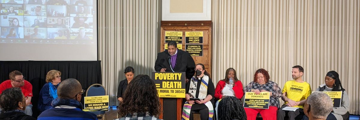 Rev. Dr. William Barber speaks at a podium with a sign reading "Poverty = Death."