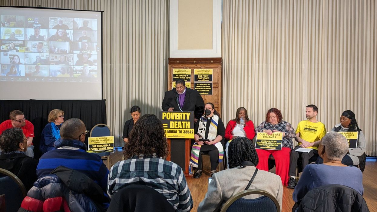 Rev. Dr. William Barber speaks at a podium with a sign reading "Poverty = Death."