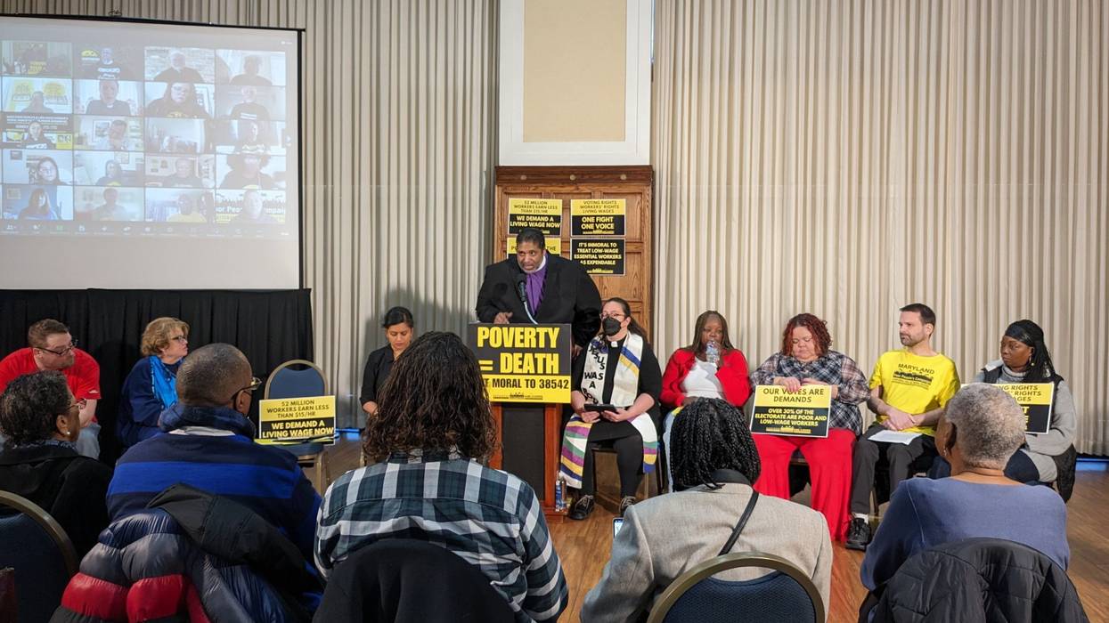 Rev. Dr. William Barber speaks at a podium with a sign reading "Poverty = Death."
