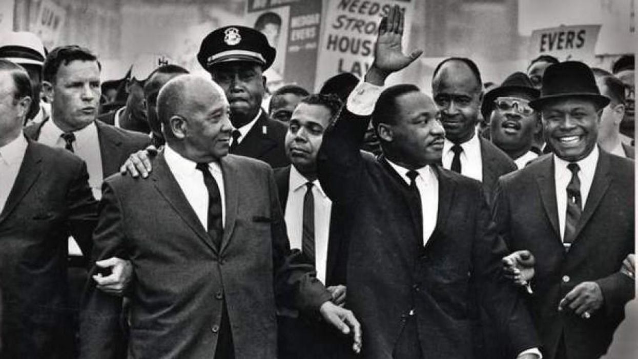 Rev. Martin Luther King Jr. waves to onlookers while leading the 125,000 strong 'Walk to Freedom' on Woodward Avenue in Detroit in 1963.