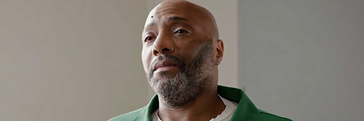 Richard Moore looks forlorn in a green prison uniform