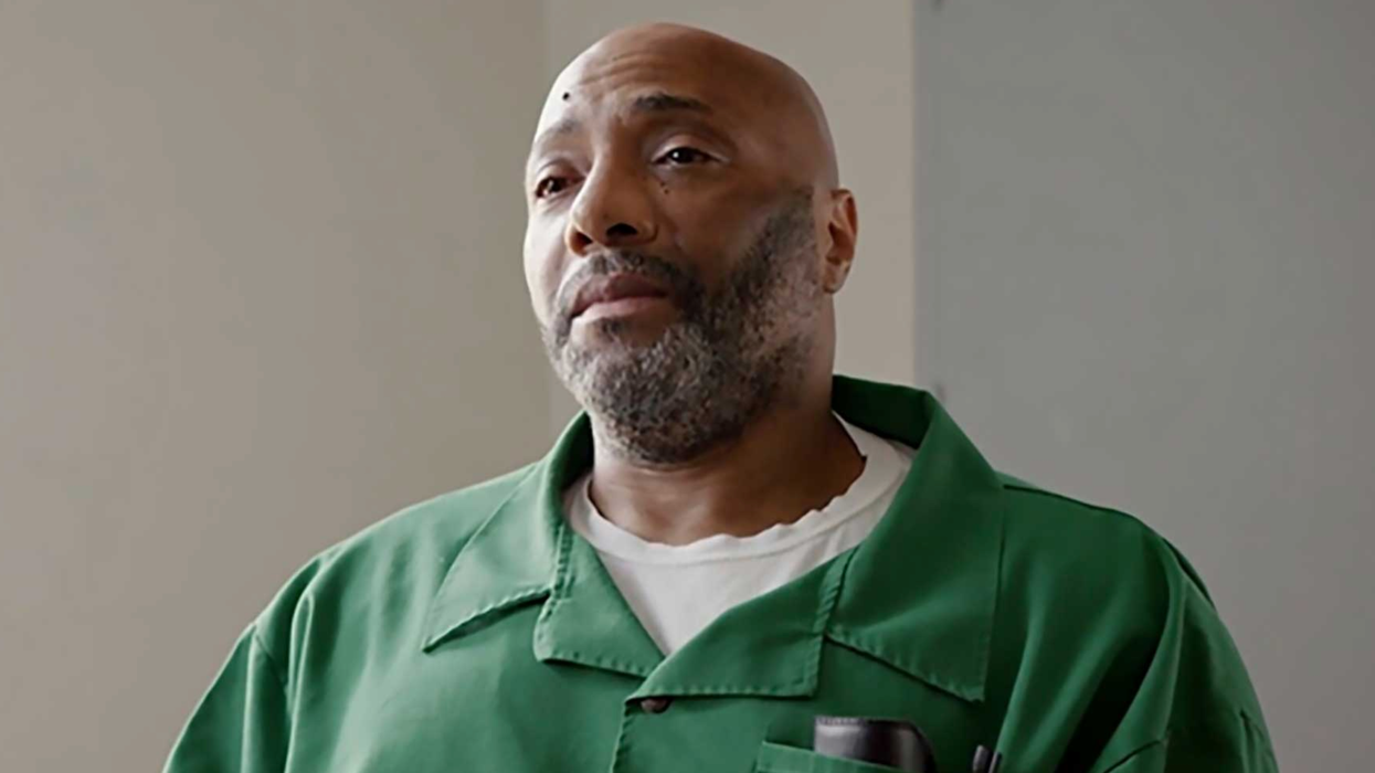 Richard Moore looks forlorn in a green prison uniform