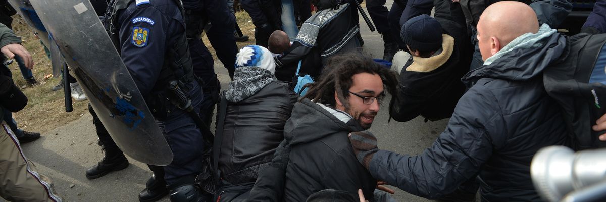 Romanian protesters scuffle with Romanian gendarmes after breaking the fence of the exploring perimeter of US energy giant Chevron in Pungesti, Romania on December 7, 2013