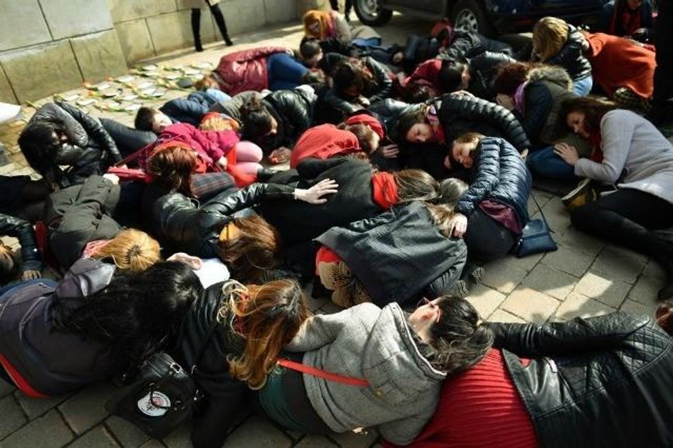 Romanian women lie on the floor of a police station to protest a lack of protection for abused women. (Photo: Getty)