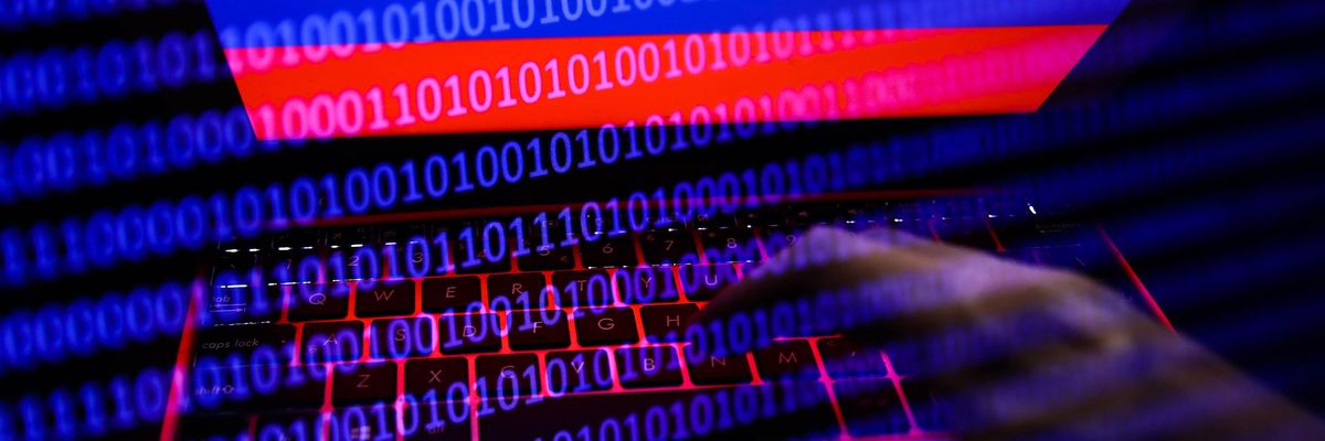 Russian flag displayed on a laptop screen and binary code code displayed on a screen are seen in this multiple exposure illustration photo taken in Krakow, Poland on February 16, 2022