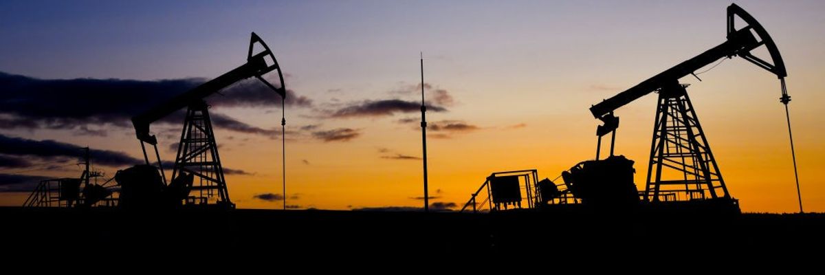 Russian oil machinery against a sunset.