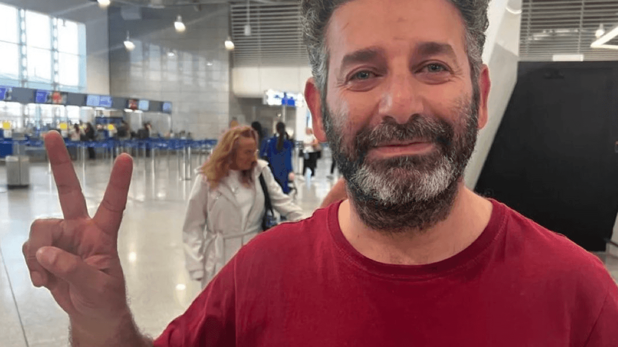 Said Abu Keshek flashes a peace sign in Athens airport