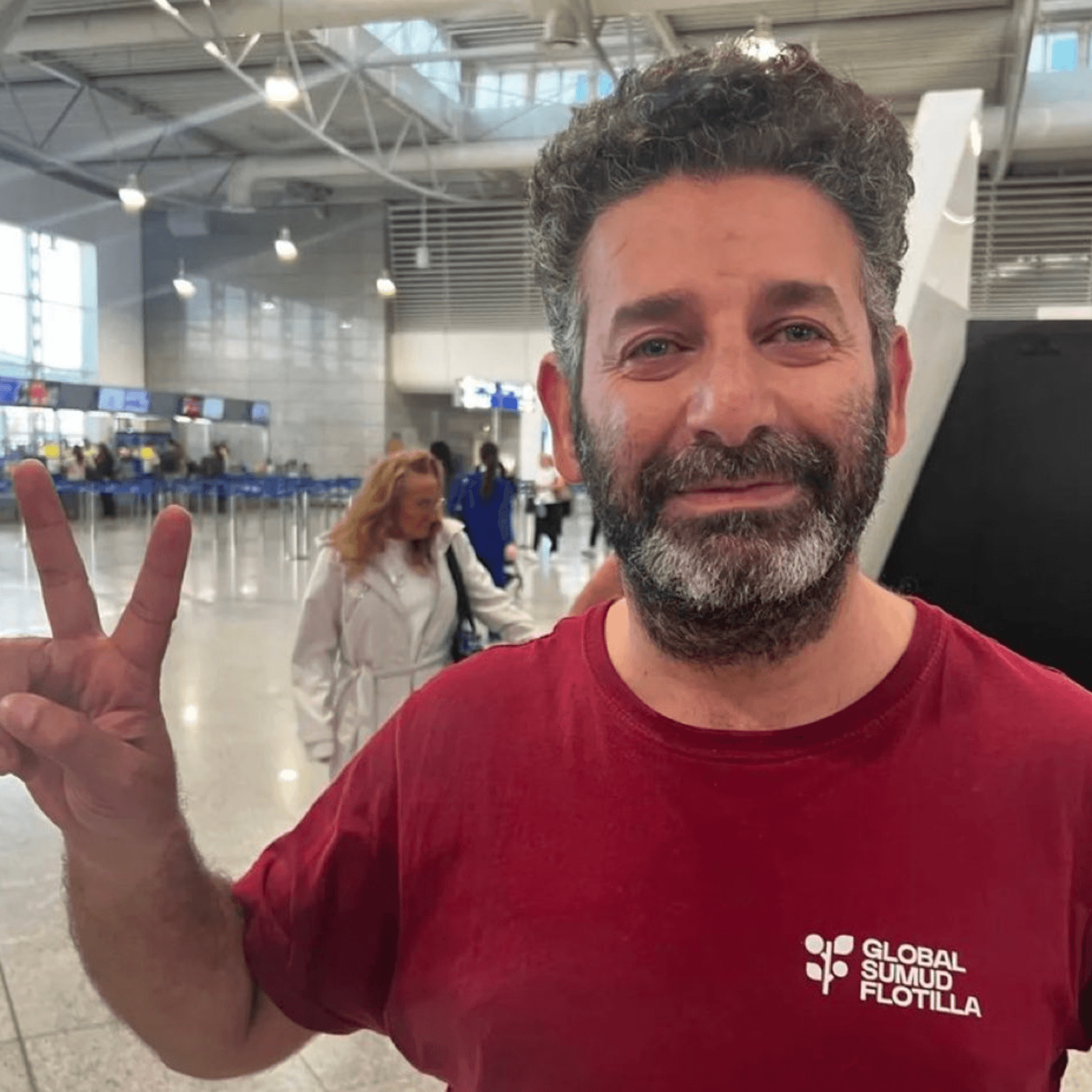 Said Abu Keshek flashes a peace sign in Athens airport