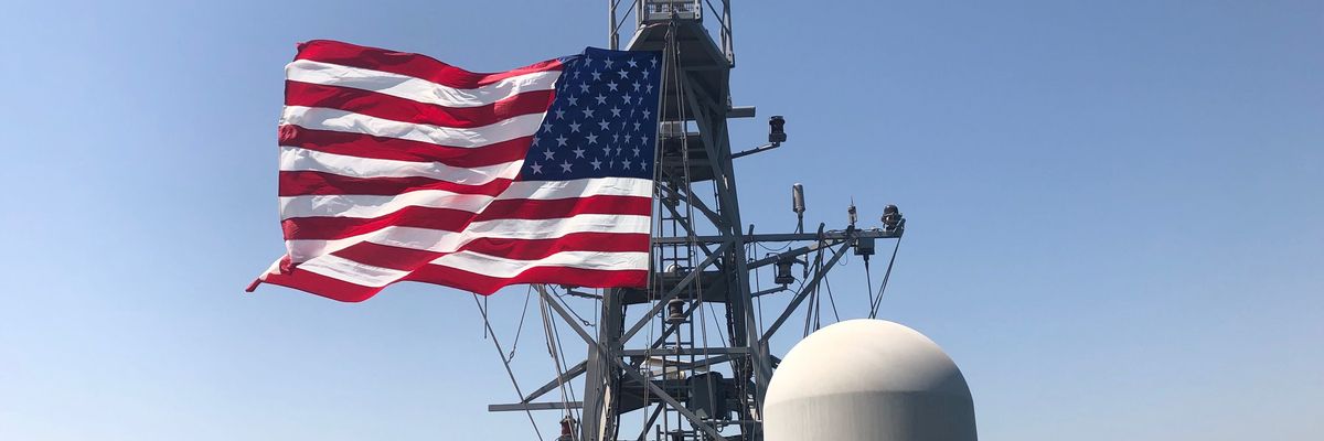 Sailors on board the USS Whirlwind display a U.S. flag