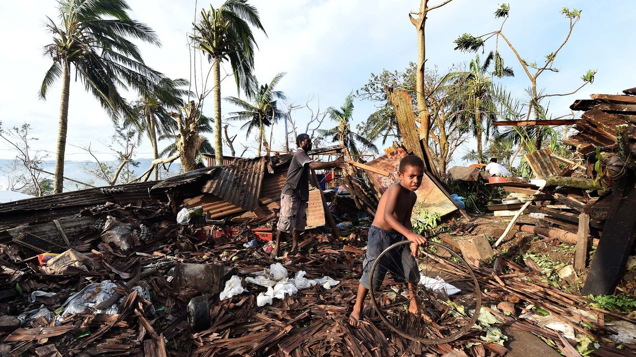 Samuel (L) and his father Phillip search through the ruins of their family home