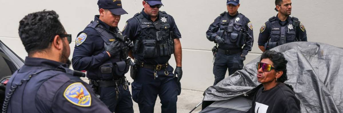 San Francisco police prepare to arrest an unhoused man during an encampment sweep