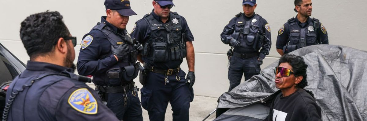 San Francisco police prepare to arrest an unhoused man during an encampment sweep