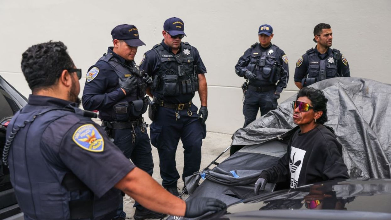 San Francisco police prepare to arrest an unhoused man during an encampment sweep