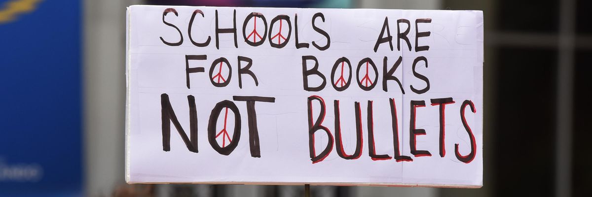 "Schools are for books, not bullets" sign at protest