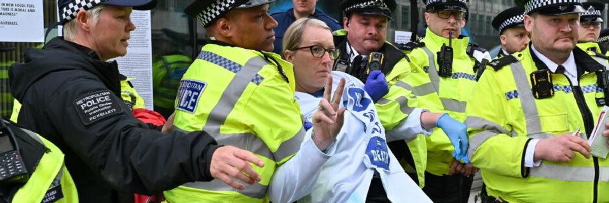 Scientist Emma Smart is arrested during a protest against climate inaction at the U.K. government's Department for Business, Energy, and Industrial Strategy in London on April 13, 2022.