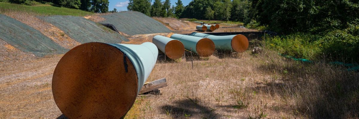 Sections of steel pipe of the Mountain Valley Pipeline lie in the sun on wooden blocks
