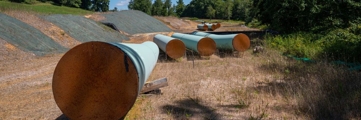 Sections of steel pipe of the Mountain Valley Pipeline lie in the sun on wooden blocks
