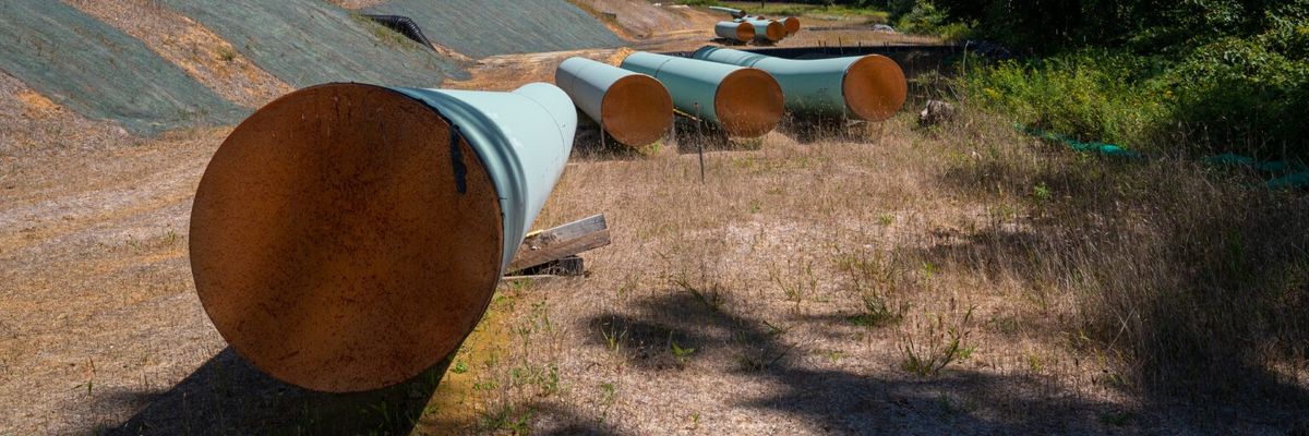 Sections of steel pipe of the Mountain Valley Pipeline lie in the sun on wooden blocks