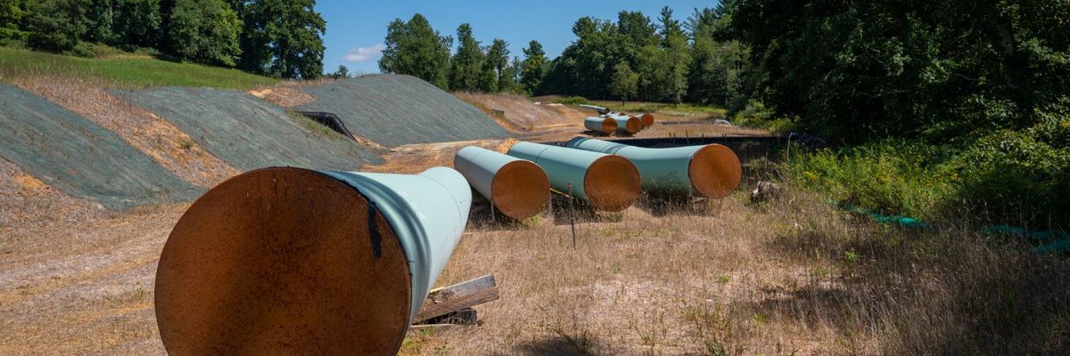 Sections of steel pipe of the Mountain Valley Pipeline lie in the sun on wooden blocks